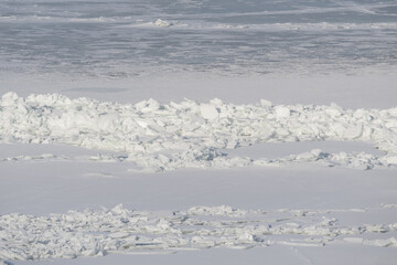 Crushed ice hummocks and frozen surface of the Baltic Sea during a severe winter season with vast snowy arctic landscape. © Dmitri