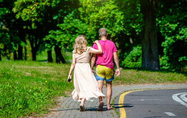 Obraz premium A man and a woman walk in a summer park