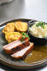 Roasted pork belly served on a plate with potatoes and cabbage salad. Traditional Czech cuisine background showcasing hearty comfort food, presented in a rustic and authentic style