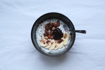 bowl of yogurt with chia, banana, nuts, berries and cocoa