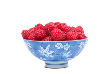 Beautiful ripe red raspberries in a bowl on a white background