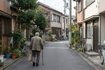Senior Man Walking Alone on a Quiet Residential Street in Japan