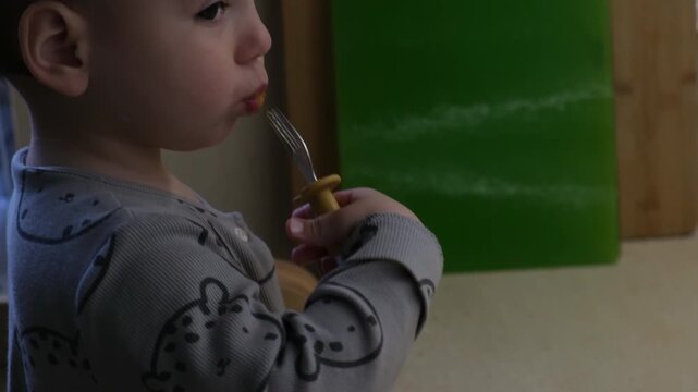 Toddler Eating with Fork in Pajamas
