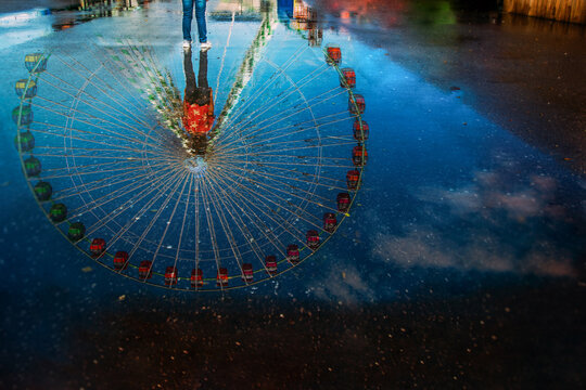 Reflection of Ferris Wheel in water puddle