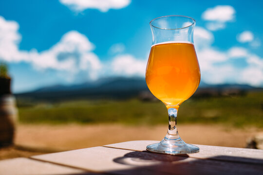 Beer sitting on table with mountains in the distance