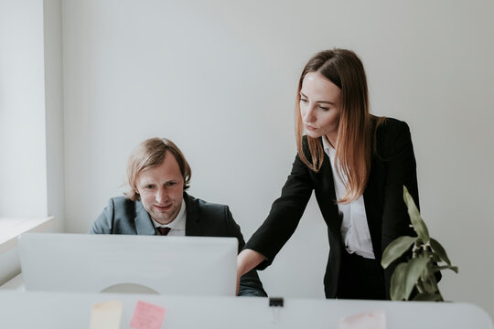 Businessman and woman working together at desk in office