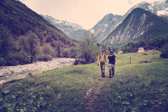 Slovenia, Bovec, two anglers walking on path towards Soca river