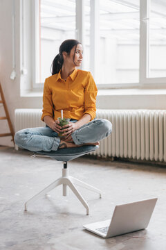 Yung woman sitting in her new flat with a laptop