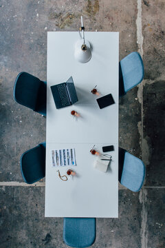 Conference table seen from above, turkish tea, prayer beads, tablet, smartphone, laptop and notebook