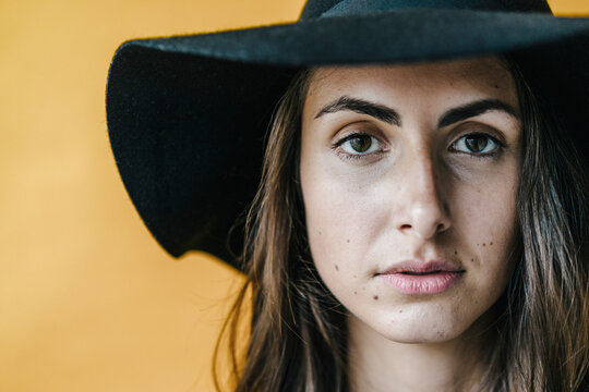 Portrait of brunette young woman wearing a floppy hat
