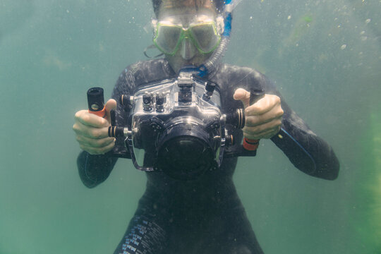 Man diving with underwater DSLR camera case