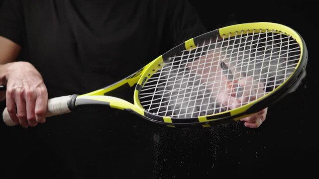 Tennis racket strings cut in slow motion. Player hands dusting