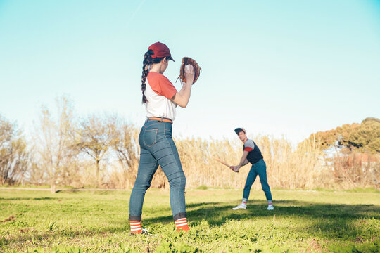 Young couple playing baseball in park