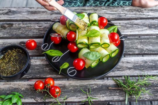 Vegetarian grill skewers, tomato and zucchini slices, brush with rosemary garlic oil