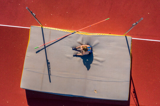 Germany, Baden-Wurttemberg, Winterbach, Female athlete sitting on mat after failed high jump