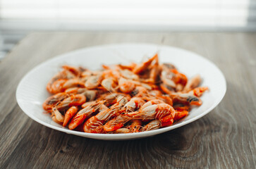 Azov shrimps boiled on a plate daylight from the window