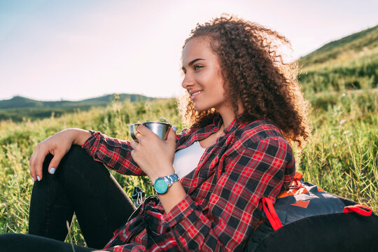 Teenage girl with thermos flask having a rest in nature