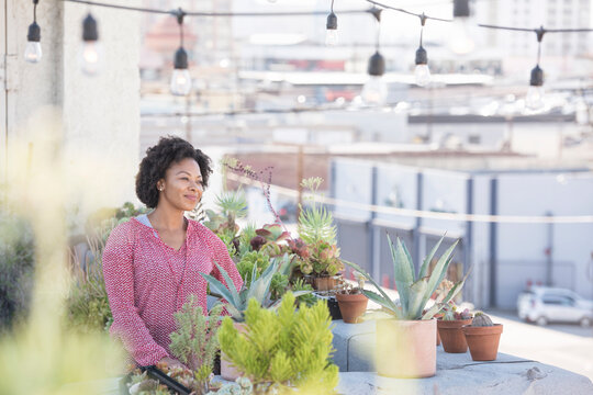 Smiling woman standing in her rooftop garden