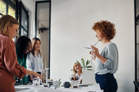 Businesswomen having a meeting in office with wind turbine models