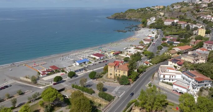 Aerial view of coastal road bordering an organized beach resort. Panorama of the beach of Scalea, in province of Cosenza, Calabria, Italy. The promenade runs along the Tyrrhenian Sea coast.