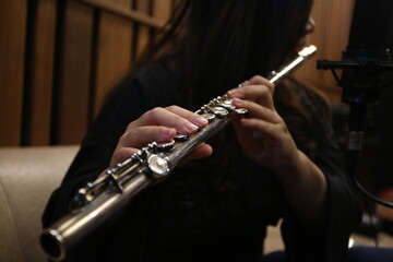 Fototapeta premium Close-up Female Musicians Playing Flute and Saxophone in Studio Rehearsal