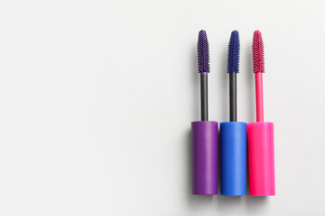 Fototapeta premium Brushes of different mascara on white background, closeup