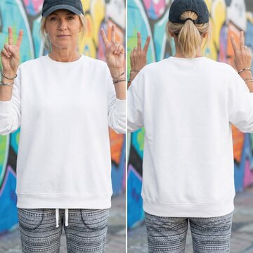 White sweatshirt mock up, both sides. Middle-aged woman in casual oversized shirt, front and back view template. Female model posing against graffiti background. Basic blank pullover mockup