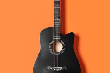 Modern black guitar on orange background