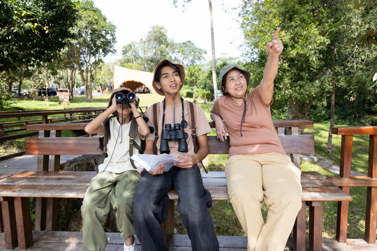 Family Bird Watching Together with Mother Pointing at Birds in Nature Park
