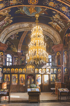 Interior of a traditional Orthodox church with ornate iconostasis and frescoes.