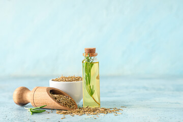 Rosemary with bottle of essential oil on blue grunge background © Pixel-Shot