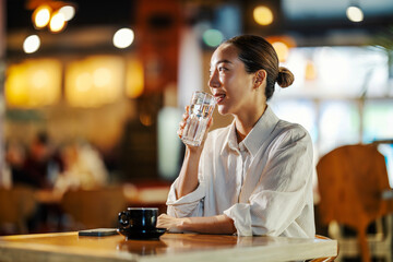 Woman drinking water in a cafe enjoying a break