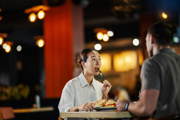 Woman eating meal with partner at restaurant