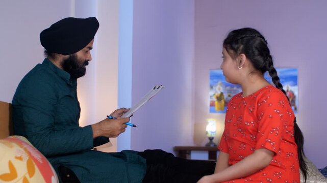 A middle-aged Punjabi Sardar with his girl kid - guidance  scolding  angry father  poor performance . An Indian father scolding his young daughter while looking at her exam papers - an angry father...