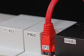 Connecting an Ethernet cable with an Rj45 connector to equipment in an electrical switchboard. 