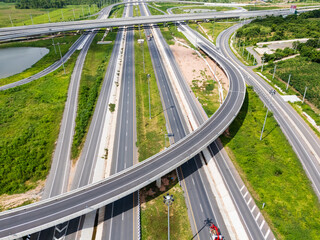 Fototapeta premium Drone shot a large highway interchange crossing over green farmlands in Thailand