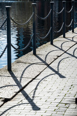 Chain fence near water and  reflections, Poplar, E14, London, England, UK