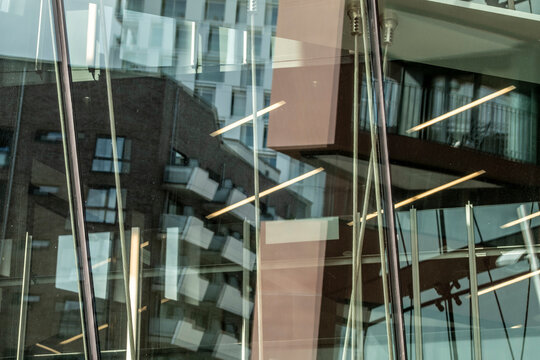 Modern office glass windows capture an abstract reflection of urban lines and geometry with subtle transparency for a calm graphic feel