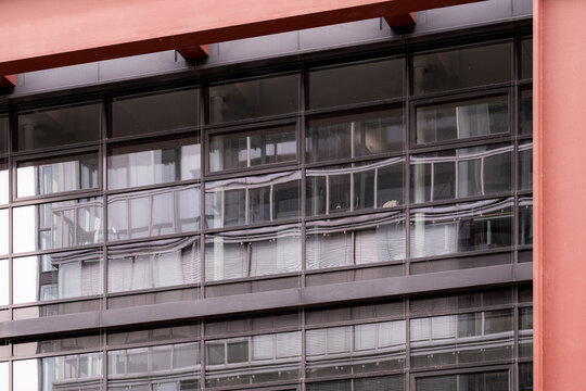 Close view of a modern architecture facade where office windows form a grid of lines in a building emphasizing structure detail and order
