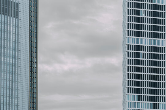 Modern urban architecture skyscraper building facade with windows framed by sky and clouds using symmetry for minimal abstract city skyline composition