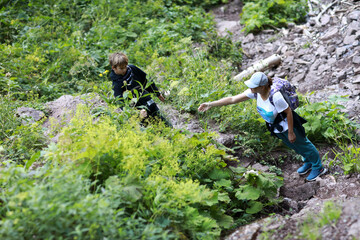 Woman and boy hiking on steep, rocky trail