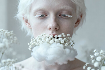 Naklejka premium Ephemeral Whisper: A serene woman, her face framed by delicate white blooms, embodies a moment of quiet introspection.