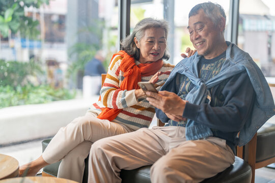 Happy senior asian couple love and laughing together outdoors, elderly husband and wife enjoying retirement lifestyle and travel in winter, active aging, insurance and health care concept