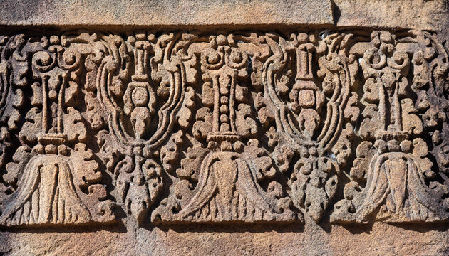Intricate stone carving floral pattern bas relief pink sandstone ancient Khmer art temple decoration history architecture archaeology detail weathered background