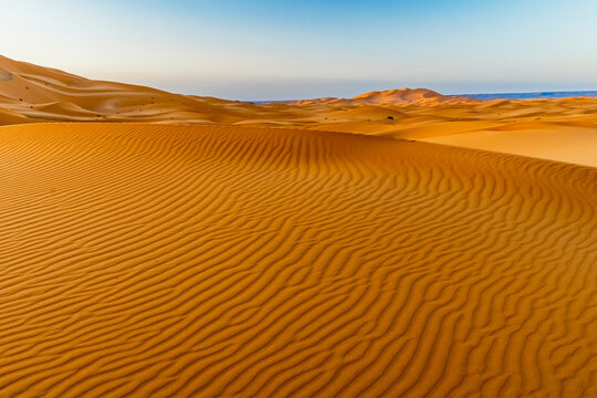 Sand dunes with wind ripple patterns under a blue sky. Mezouga,Sahara desert,Morocco