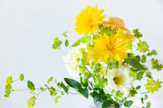 花びんに活けた黄色いひまわり、白いトルコキキョウ、バーベナの花　フラワーアレンジメント　花のある暮らし