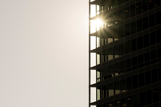 Sunlit modern glass office building facade with reflective minimal architecture lines and generous space for clean corporate design background