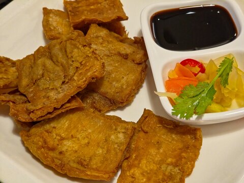 Chinese Style Crispy Deep-Fried Pork Intestines Served with Sweet Soy Dipping Sauce and Pickled Vegetables. Top view.