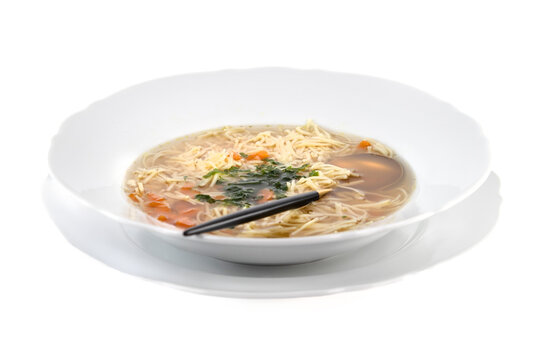 Polish Rosol, chicken soup with egg pasta and vegetables close-up 