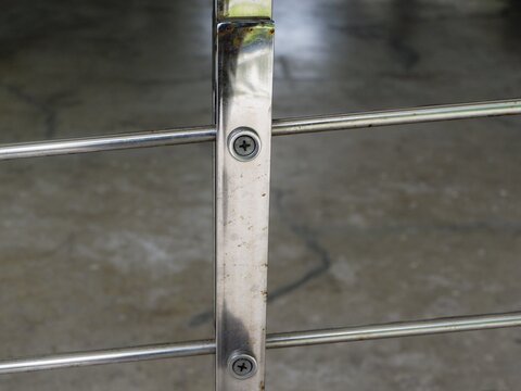 A sharp close-up of a modern stainless steel cable railing system with visible screw fixings. The minimalist industrial design is ideal for contemporary architectural and safety feature concepts.